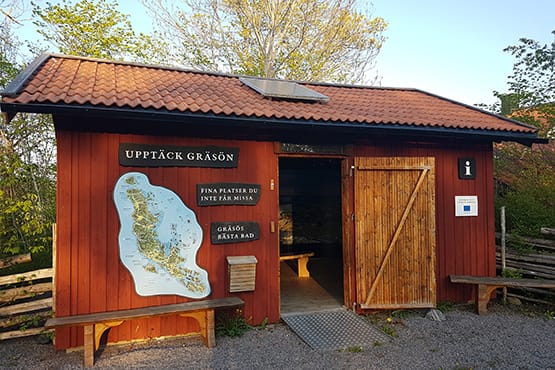 Informationsbyggnaden är en faluröd trästuga med en Gräsökarta på fasaden.